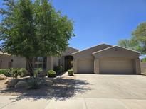 Charming single-story home with a two-car garage, mature landscaping, and a neutral color palette at 18359 W Sweet Acacia Dr, Goodyear, AZ 85338