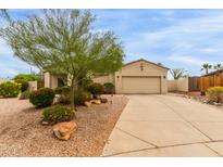 Charming single-story home with a two-car garage, desert landscaping, and a concrete driveway at 18415 W Capistrano Ave, Goodyear, AZ 85338