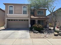 Charming two-story home features a two-car garage, desert landscaping, and covered porch at 2411 W Lucia Dr, Phoenix, AZ 85085