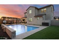 Stunning backyard pool featuring a basketball hoop, hot tub, and ambient lighting, perfect for outdoor entertaining at 2915 W Night Owl Ln, Phoenix, AZ 85085