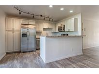 Stylish kitchen with white cabinets, stainless steel appliances, and an open breakfast bar at 4950 N Miller Rd # 233, Scottsdale, AZ 85251