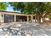Stunning home exterior with a three-car garage, brick driveway and lush tree providing ample shade at 5440 E Calle Camelia --, Phoenix, AZ 85018