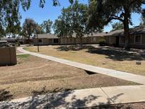 Apartment complex exterior featuring mature trees and well-maintained sidewalks at 6711 W Osborn Rd # 138, Phoenix, AZ 85033