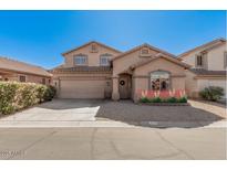 Charming two-story home featuring a well-manicured lawn and a two-car garage under a clear blue sky at 8802 E University Dr # 28, Mesa, AZ 85207