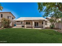 Expansive backyard featuring lush green grass and a covered patio, perfect for outdoor relaxation at 9135 W Hazelwood St, Phoenix, AZ 85037