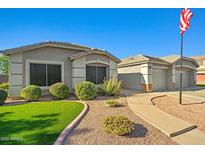 Inviting single-story home with well-manicured lawn and a charming walkway to the garage at 16396 W Fillmore St, Goodyear, AZ 85338