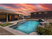 Inviting backyard pool and patio area with outdoor kitchen, perfect for entertaining and relaxation with a stunning sunset at 18319 W Marshall Ave, Litchfield Park, AZ 85340
