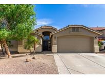 Inviting home with a two-car garage, desert landscaping, and a charming entrance at 42277 W Chisholm Dr, Maricopa, AZ 85138
