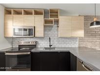 Stylish kitchen with stainless steel appliances, subway tile backsplash and modern wooden cabinetry at 4701 N 68Th St # 214, Scottsdale, AZ 85251