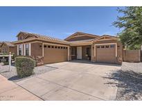 Charming single-story home featuring a three-car garage, tile roof, and well-maintained landscaping at 6815 W Carter Rd, Laveen, AZ 85339
