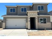 Two-story home boasts a neutral color palette with stone veneer accents and a two-car garage, offering modern curb appeal at 7385 W Buckhorn Trl, Peoria, AZ 85383