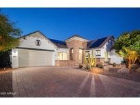 Charming single-Gathering home featuring desert landscaping, solar panels, and a paver driveway at 7590 W Firebird Dr, Glendale, AZ 85308