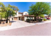 Inviting two-story home featuring a well-maintained yard and a spacious two-car garage, set under a clear, blue sky at 7925 S 52Nd Dr, Laveen, AZ 85339