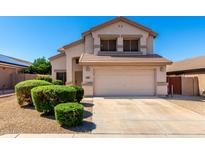 Two-story home with a two-car garage, gravel landscaping and manicured bushes at 8755 E Portobello Ave, Mesa, AZ 85212