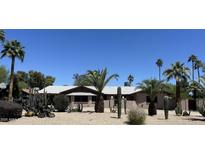 Charming single-story home featuring desert landscaping with mature palm trees and various cacti at 5514 E Pershing Ave, Scottsdale, AZ 85254