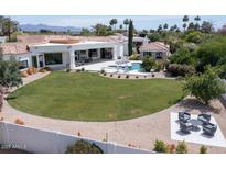 Aerial view of the property showcases lush landscaping, a pool, and multiple outdoor seating areas at 6443 E Malcomb Dr, Paradise Valley, AZ 85253