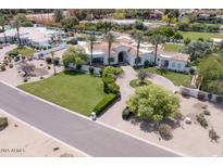 Elegant home with palm trees, green lawn and circular driveway at 6443 E Malcomb Dr, Paradise Valley, AZ 85253