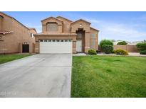 Two-story home featuring a well-kept lawn, large driveway and a two-car garage at 665 S Balboa --, Mesa, AZ 85206