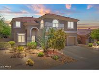 Charming two-story home with a desert landscaped yard, archway entry and a red tile roof at 10415 E Rosemary Ln, Scottsdale, AZ 85255