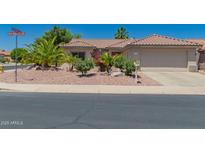 Charming single-story home with a well-maintained front yard and a two-car garage in a sunny neighborhood at 16536 W Rock Springs Ln, Surprise, AZ 85374