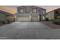 Inviting two-story home featuring a three-car garage and a spacious concrete driveway with ample parking at 23420 N 121St Ave, Sun City, AZ 85373