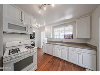 Bright kitchen features white cabinets, laminate countertops, and modern appliances at 3317 N 10Th Ave, Phoenix, AZ 85013