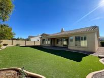 A well maintained backyard with artificial grass, an extended covered patio, and desert landscaping at 3840 E San Mateo Way, Chandler, AZ 85249