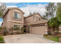Two-story home features a three car garage, desert landscaping, and a charming balcony at 4254 S Winter Ln, Gilbert, AZ 85297