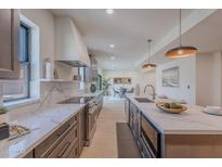 Modern kitchen with stainless steel appliances, large island and marble countertops at 5525 E Waltann Ln, Scottsdale, AZ 85254
