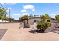 Tan-colored home exterior with a landscaped yard and gray trim around the windows at 5833 N 10Th St, Phoenix, AZ 85014