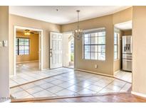 Open living space with tile floors, decorative light fixture, and natural light from large window at 6885 E Cochise Rd # 129, Paradise Valley, AZ 85253