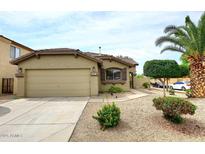 Charming home featuring a two-car garage, desert landscaping, and a mature palm tree in the front yard at 8341 W Gross Ave, Tolleson, AZ 85353