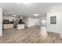 Open-concept living space featuring tile floors, neutral paint, and modern stainless steel appliances at 9863 W Country Club Ct, Sun City, AZ 85373