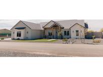 Beautiful exterior elevation featuring a quaint porch with stone and wooden posts, and desert landscaping at 1228 N 106Th Pl, Mesa, AZ 85207