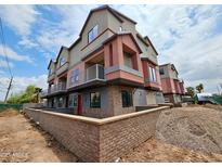 Townhouse exterior featuring a red door, brick accents, balconies, and modern architectural design at 1401 S Rita Ln, Tempe, AZ 85281