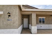 Inviting front entryway showcasing the front door and porch columns with stucco at 20411 W Mountain Sage W Dr, Buckeye, AZ 85326
