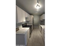Well-lit kitchen featuring white cabinets, marble countertops, and stainless steel appliances at 2121 W Royal Palm Rd # 1014, Phoenix, AZ 85021