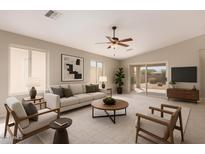 Bright living room with vaulted ceiling, ceiling fan, and sliding glass door leading to the backyard at 3631 E Long Lake Rd, Phoenix, AZ 85048
