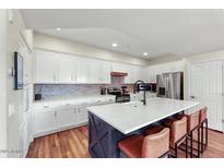 Bright kitchen features white cabinets, stainless appliances, and a large island with seating at 3935 E Rough Rider Rd # 1016, Phoenix, AZ 85050