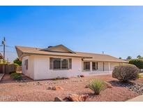 Charming single-story home featuring well-maintained landscaping and a classic design under a clear blue sky at 5633 E Colby St, Mesa, AZ 85205