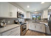 Bright kitchen with stainless steel appliances, white cabinets, and gray subway tile backsplash at 750 E Northern Ave # 2143, Phoenix, AZ 85020