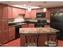 Charming kitchen with stainless steel appliances, granite countertops, and decorative lighting fixtures at 7970 E Camelback Rd # 209, Scottsdale, AZ 85251