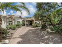 Elegant home exterior featuring a circular driveway, stone accents, and lush desert landscaping at 8229 N Ridgeview Dr, Paradise Valley, AZ 85253