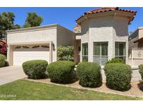 Charming single-story home featuring a well-manicured lawn, stucco exterior, and a two-car garage at 9484 N 105Th Pl, Scottsdale, AZ 85258