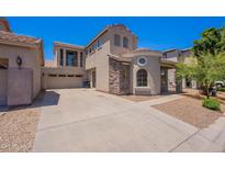 Inviting two-story home featuring a stone facade, balcony, and spacious driveway at 1244 S Tacoma --, Mesa, AZ 85209