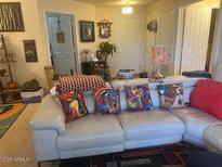 Comfortable living room featuring a white sofa with colorful pillows and decor at 14950 W Mountain View Blvd # 5303, Surprise, AZ 85374