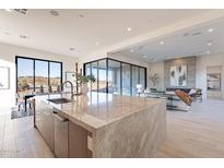 Bright open-concept kitchen features a large island with seating and seamless access to the living room at 25564 N 119Th St, Scottsdale, AZ 85255
