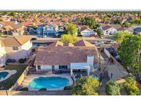 Spacious home features a backyard pool, covered patio, and tiled roof with mature trees in a friendly neighborhood at 3058 E Nance St, Mesa, AZ 85213