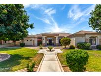 Beautiful single-story home featuring lush landscaping, a paved walkway, and a welcoming entrance at 320 N Portland Ave, Gilbert, AZ 85234