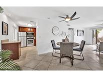 Bright dining area with a modern ceiling fan, adjacent to an updated kitchen and sliding glass doors to the patio at 4354 N 82Nd St # 167, Scottsdale, AZ 85251